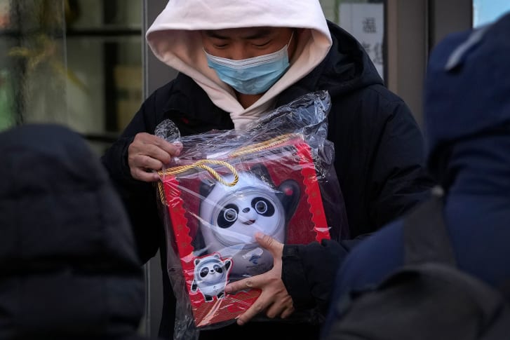 A man holding the Bing Dwen Dwen mascot